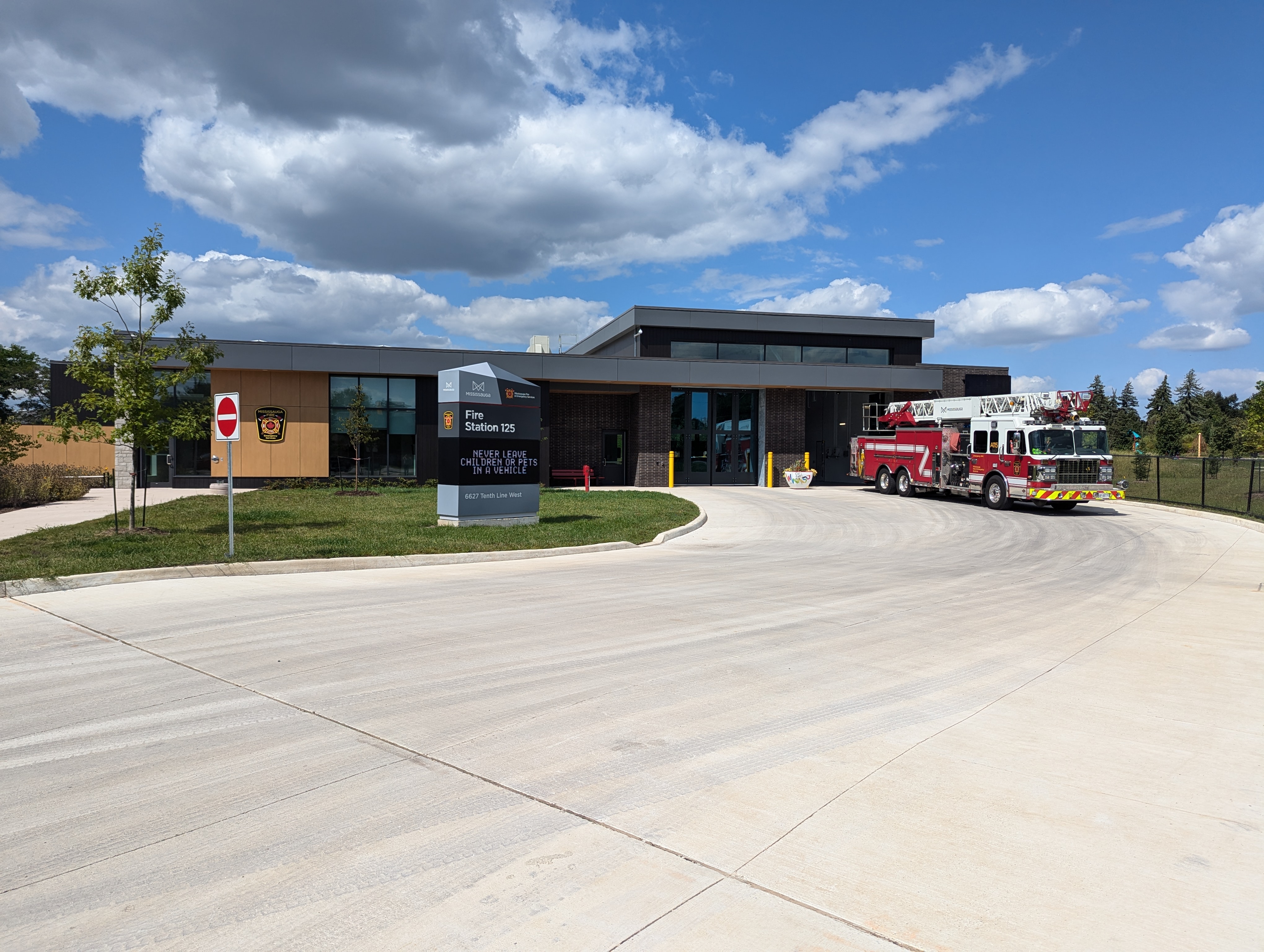 A fire truck parked at a fire station with blue sky behind