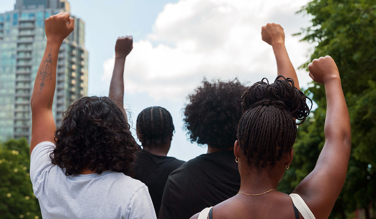 A group of youth with arms raised in solidarity. 