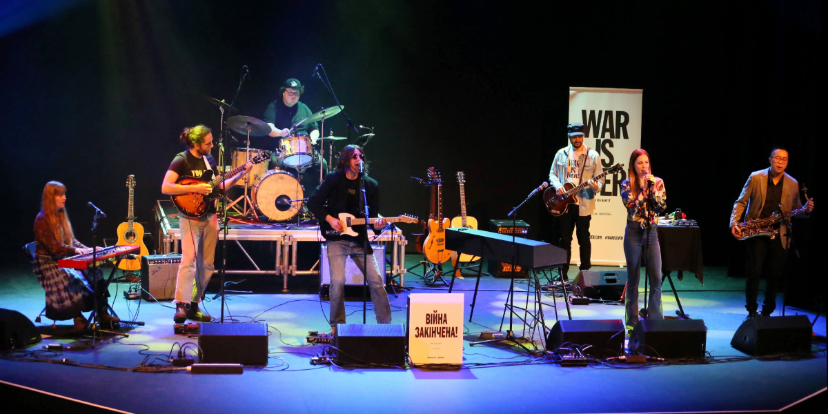 The members of Lennon.Live performing on stage.