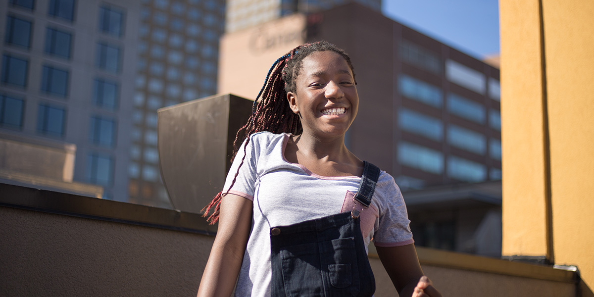 A teenage standing on a rooftop garage.