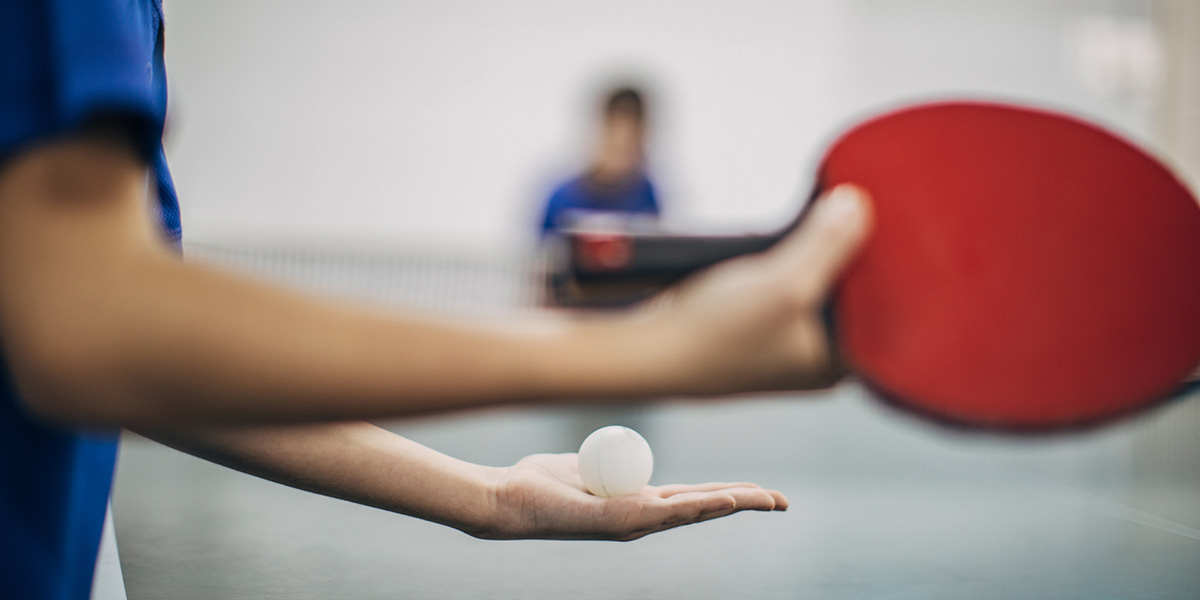 A person getting ready to serve in table tennis.