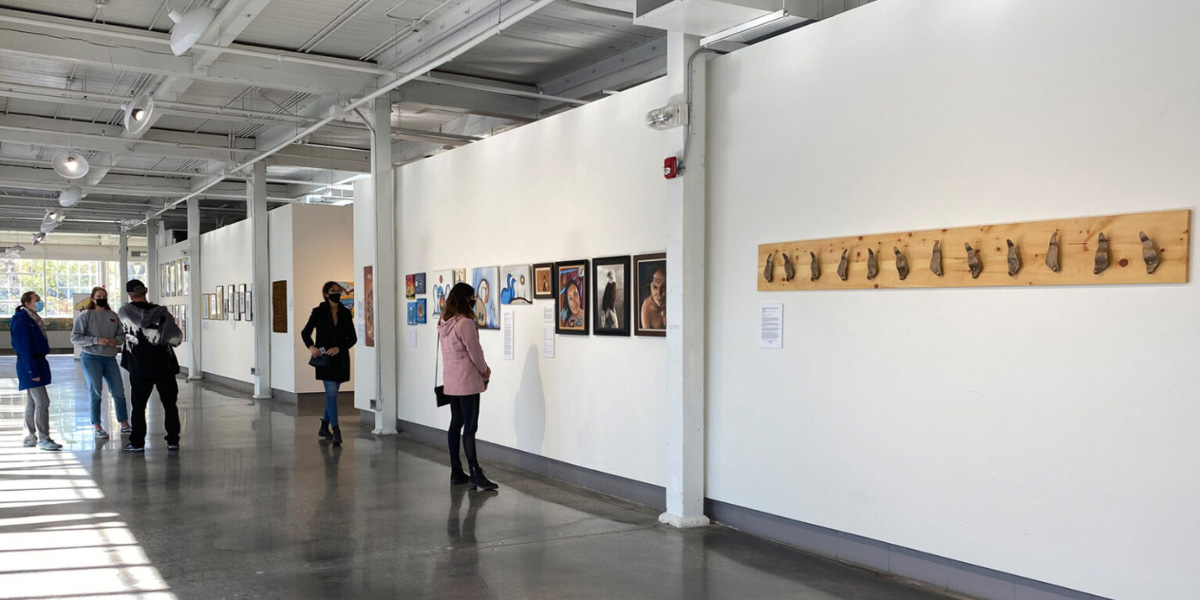 A group of people looking at artwork in the Small Arms Inspection Building.