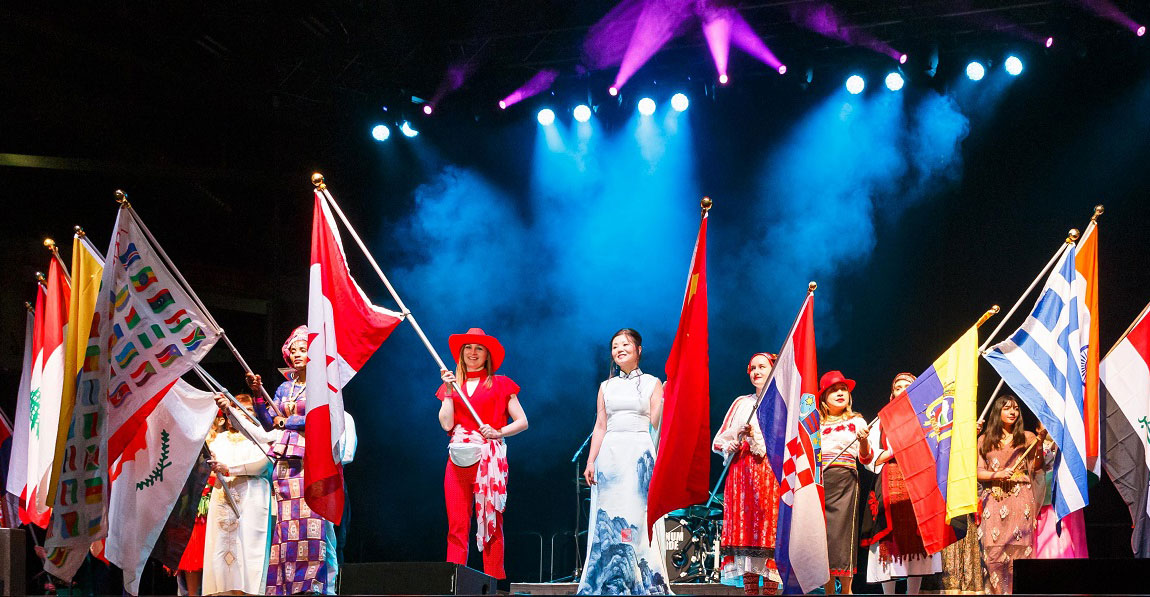 Carassauga participants on stage holding flags