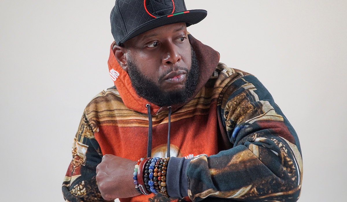 Talib Kweli wearing a black baseball hat