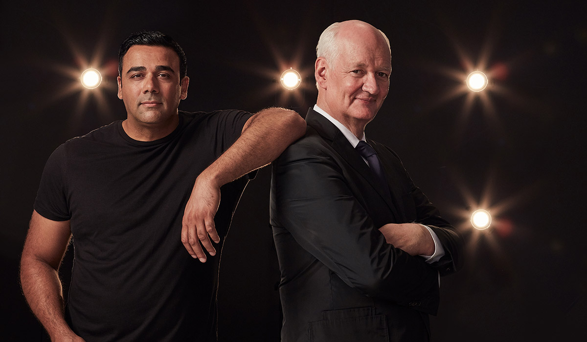 Colin Mochrie and Asad Mecci in front of a black background