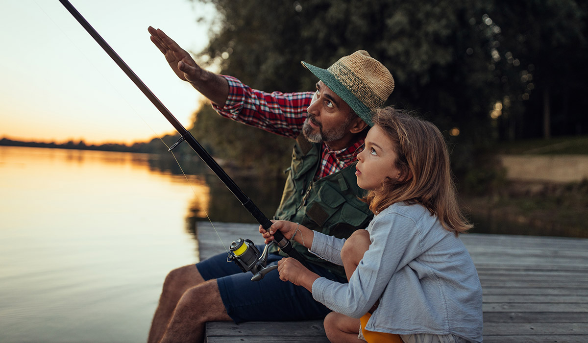 A father and daughter fishing on a dock