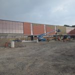 Construction workers and equipment at the new addition of the Carmen Corbasson Community Centre, with exterior glazing being installed.