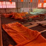 Tarps and wooden construction materials sit where the therapy tank will be built.