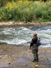 An angler calmly fishes for salmon with hip waders and a fly fishing rod on the banks of the Credit River in Mississauga.