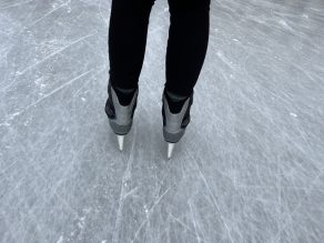 Someone skating on ice with skates on