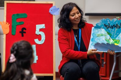 Librarian holding a book while reading to a child during story time