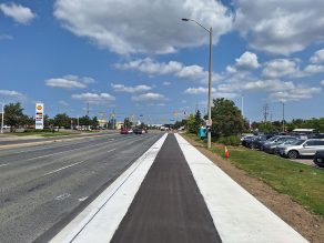 Image of a cycle track separated from the street with white paint for walkways. 