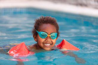 A small child swimming with floaties