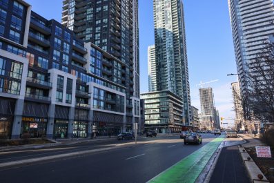 Buildings of different styles and heights on left side of the road