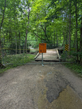 Barricades and signage along a flooded City trail