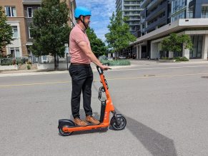 Person riding shared e-scooter on road