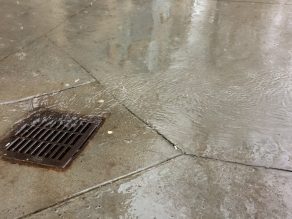A stormwater drain draining water from a sidewalk