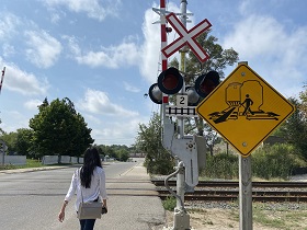 Person walking across designated railway crossing.