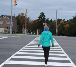 Person crossing crosswalk at dusk