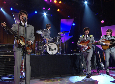 The Fab Four band performing on stage.