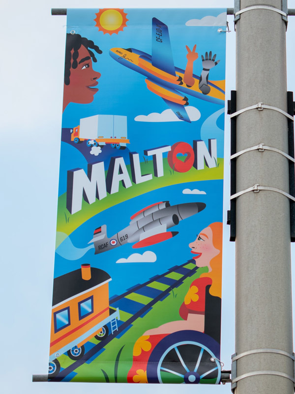 A vinyl street banner mounted a light pole.