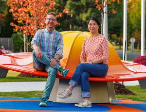 Christine Leu and Alan Webb sitting on Fungi of the Woods.