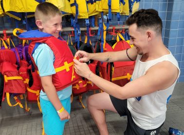 Lifeguard helping child with lifejacket
