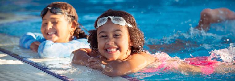 two girls in the pool with googles